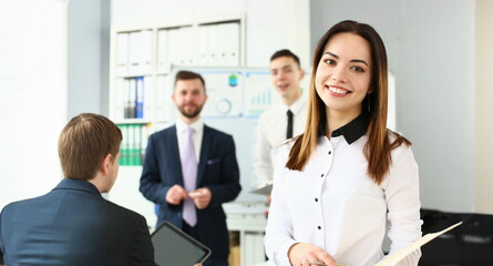 Portrait of smiling manager posing with colleagues in office, stylish look for work. Businesswoman work in successful company. Career growth and teamwork concept