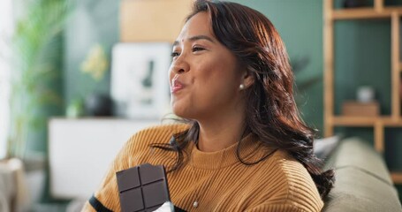 Woman, relax and eating chocolate in home or smile with candy bar for sugar craving. Cacao, candy and girl on sofa in apartment with dessert, sweets and happy with snack, treats or plan to diet