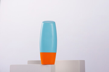 Blue cosmetic bottle, Skin care or sunscreen cosmetic with stylish props on white background.
