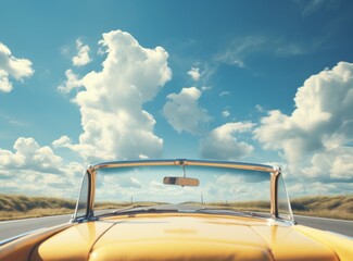 Fototapeta premium Close-up of a retro car on the road with a blue sky and clouds in the background.