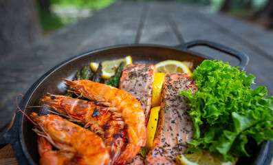 Healthy baked salmon steaks with greens and asparagus in a black cast iron skillet. A delicious low-carb breakfast.