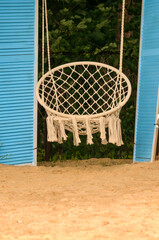 Rope hanging outdoor rocking chair. Summer holiday, vacation concept. Vertical image