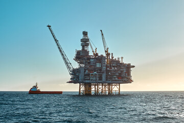 Offshore oil and gas jackup platform, during cargo operations with supply vessel in the sea on...
