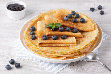 Crepes, thin pancakes with blueberry jam and fresh berries