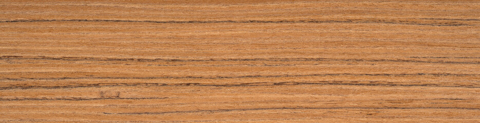 Teak wood veneer surface with warm golden hues interlaced with rich brown grain lines