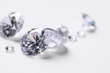 Many beautiful shiny diamonds on white background, closeup