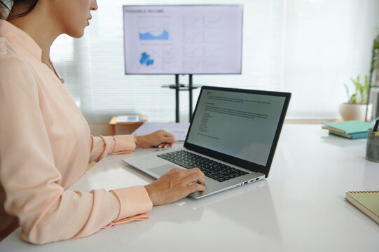 Young businesswoman developing vlm model on laptop while working in marketing department