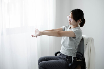 Woman having back body pain during work long time. stretching to relax and relax while working hard at the office