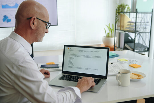Senior marketer developing vlm model on laptop while working in office