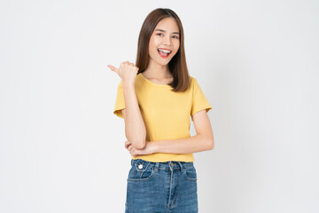 Happy casual Asian girl student shows hand pointing to the sideway, isolated on white background.