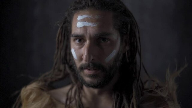 Prehistoric hunter looking at camera prepared for hunting, ancient war