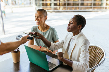 Businesswoman making a payment at a cafe