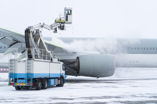 De-icing the aircraft before the flight. The deicing machine sprinkles the wing of a passenger plane with antifreeze. Winter at the airport. Snow. Aviation handling. Steam in the cold. Airport service
