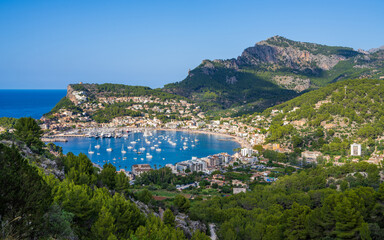 Obraz premium Beautiful view of the harbor with many yachts, ships in the Balearic village of Puerto de Soller, a popular holiday destination in Mallorca. Sunny day, vacation time.