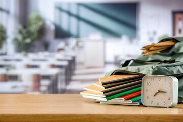 School backpack and school stuff with space for products on wooden desk in classroom  interior. Chalkboard wall background. Back to school. Copy space for school supplies and accessories.