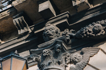 The lantern and doorway are made in the form of a portal arch with a sculptural group of mascarons in the form of a head and seraphim. Ancient architecture of the Lviv Historical Museum, Ukraine.
