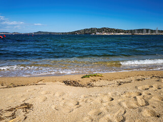 Beach with waves in Port Grimaud looking towards Saint Tropez in France in spring, close-up