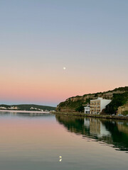 Puesta de sol sobre el mar mediterráneo en una bahia en la isla de menorca