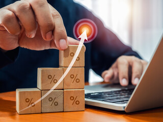 Arrow hit on target icon, graphic on wooden cube blocks as growth graph steps with percentage icon, arrange by hand. Business investment, market goal and success, savings, profit and income concepts.