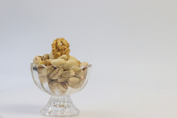 Walnuts and Pistachio in glass bowl with isolated white background