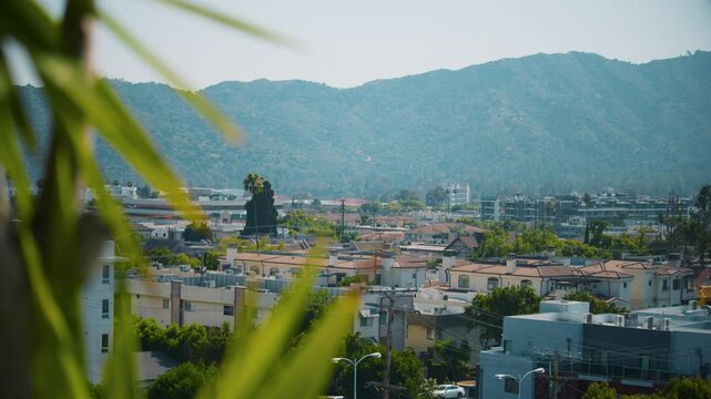A view of a city at the foot of the mountains on a summer day. Overlook of Glendale, California in bright sunshine. Suburban neighborhood of a warm southern city.