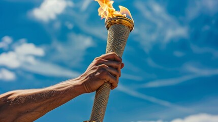 Torch in the hands of a man on a background of blue sky