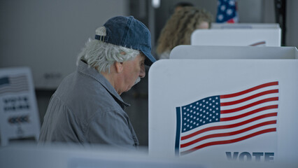 Multicultural American citizens come to voting booth in polling station office. National Election...