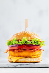 Chicken burger with bacon on a marble board. Selective focus