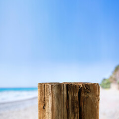 Old wooden stump as table background with beach and seascape view. Copy space for products and...