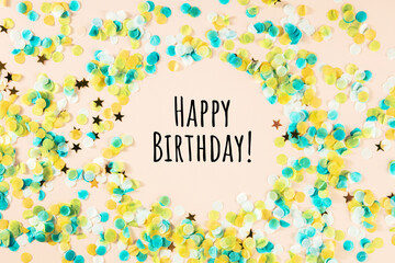 Happy birthday greeting card with confetti, golden stars, with typography, on a pink background