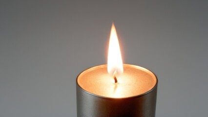  a lit candle in a silver container,