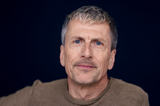 Senior man with wrinkles against black background
