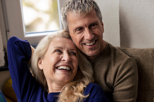 Cheerful retired senior couple relaxing together at home