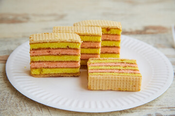 Pieces of sponge cake with jam on a white disposable plate.