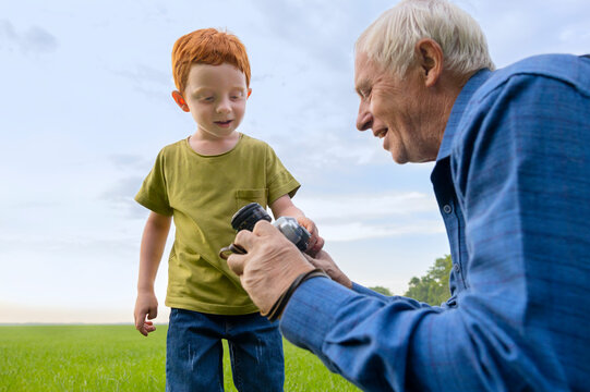Senior man shows his grandson old camera