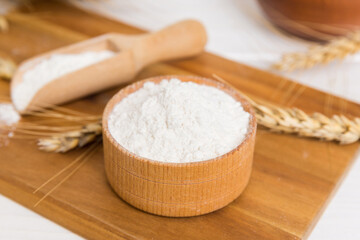 Flat lay of Wheat flour in wooden bowl with wheat spikelets on colored background. world wheat crisis