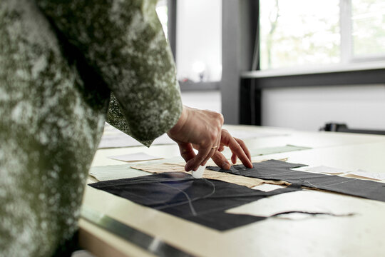 Fashion designer marking on fabric at workshop