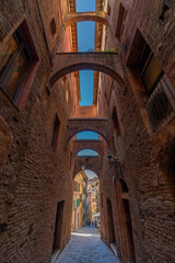 Siena, Italy - June 01, 2024: Beautiful street of siena. Building with arch. Bottom to top view.