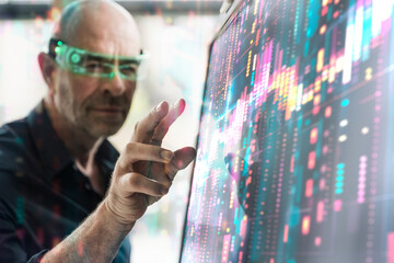 Doctor wearing smart glasses gesturing by screen at laboratory