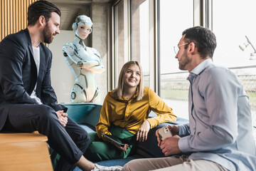 Business team discussing with humanoid robot in office