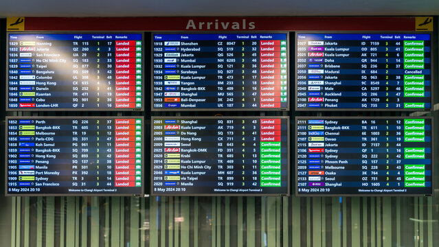 Changi Airport, Singapore - May 8, 2024: Large Arrivals Board in Singapore Changi International Airport viewed from the terminal corridor