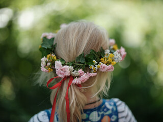 Naklejka premium Child with floral wreath in hair from behind