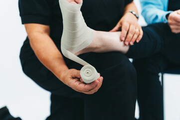 Closeup of doctor wrapping bandage around persons foot