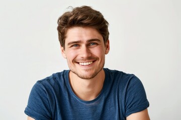 Obraz premium Young handsome guy in blue t-shirt posing close up on grey background
