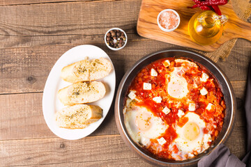 Shakshuka made of poached eggs in tomato pepper sauce