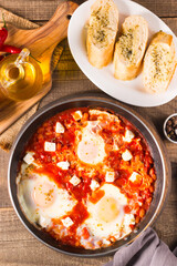 Shakshuka made of poached eggs in tomato pepper sauce