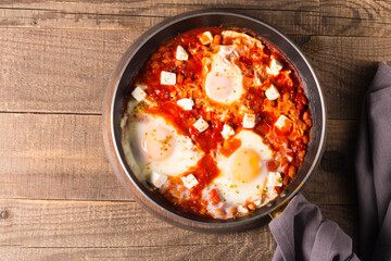 Shakshuka made of poached eggs in tomato pepper sauce
