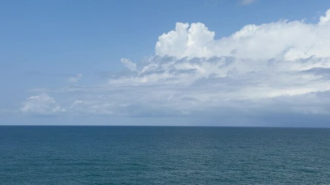 Calm blue sea and beautiful clouds in the sky on horizon.
