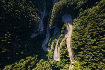 Aerial view of the road passing through the mountain and green forest. Curve asphalt road on mountain.	
