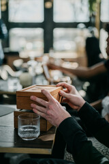 Person in restaurant stacking small wooden boxes on top of eachother